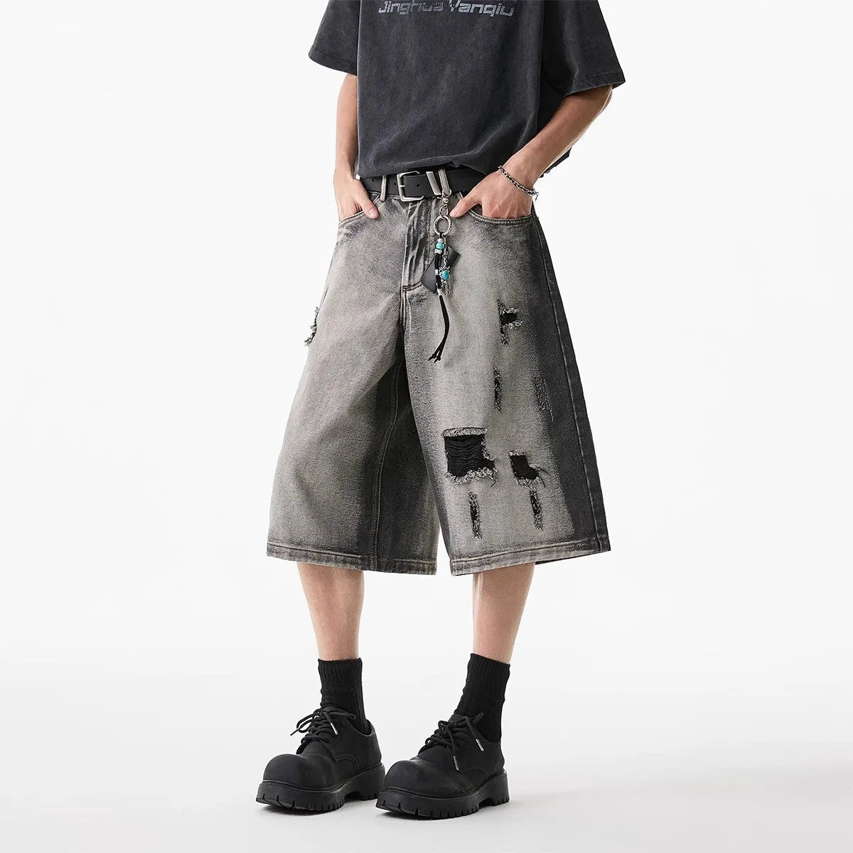 Grey denim shorts with loose fit and cropped length on hanger