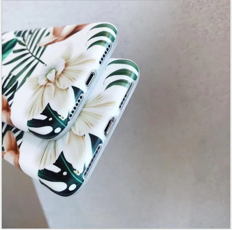 Soft TPU iPhone case with detailed floral and banana leaf art in green tones on the back.