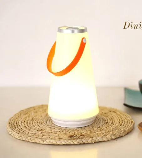White rechargeable LED bedside night light with touch control on a wooden table.