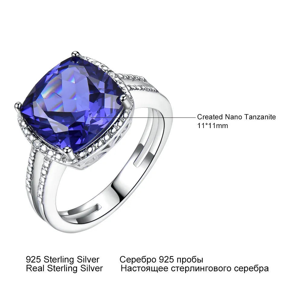 Blue tanzanite gemstone set in a silver women's ring on a finger.