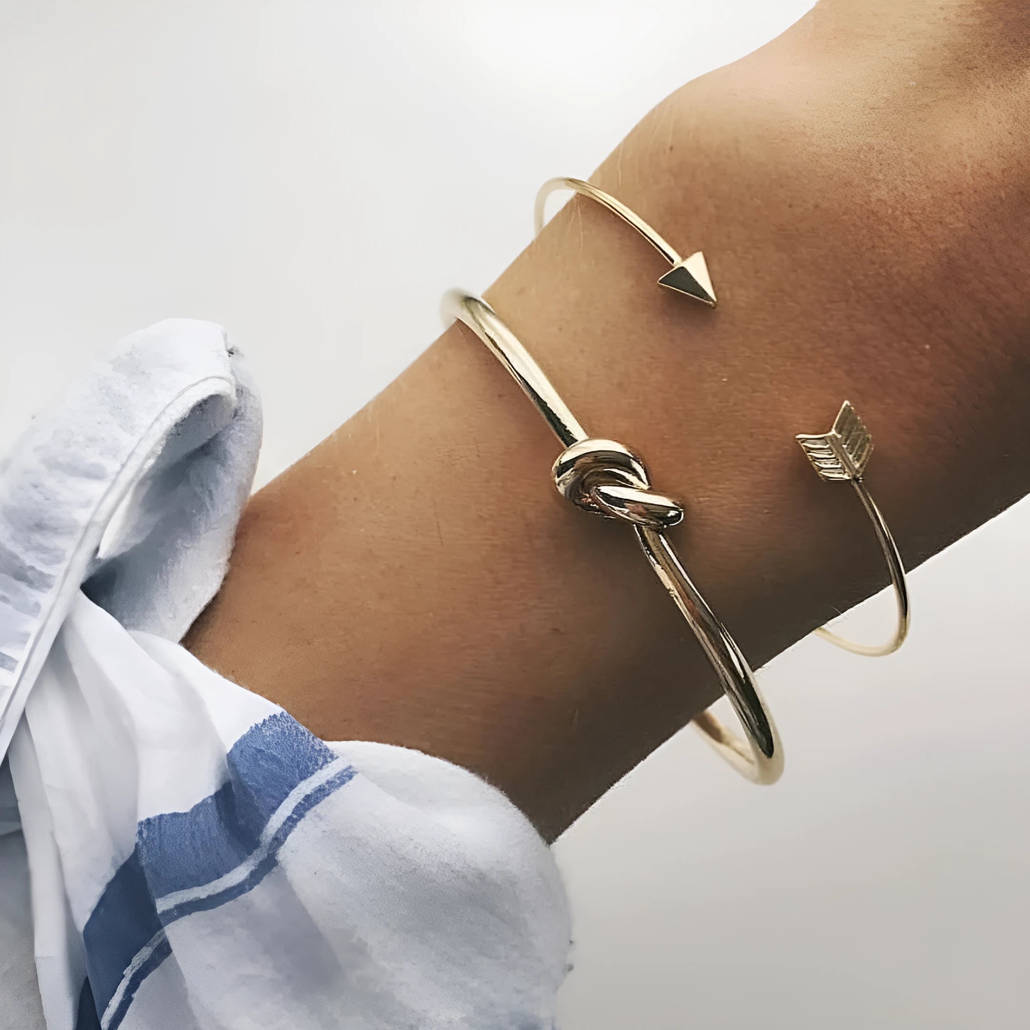 Gold electroplated vintage women's cuff bracelet with arrow and knotted design.