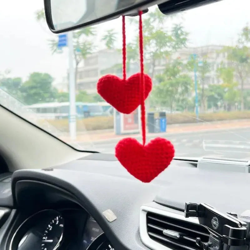 Green and white knitted wool car plant ornament with basin base and hanging rope.