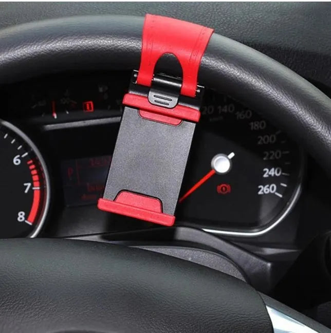 Black steering wheel phone clip mount holding smartphone with soft silicone padding visible