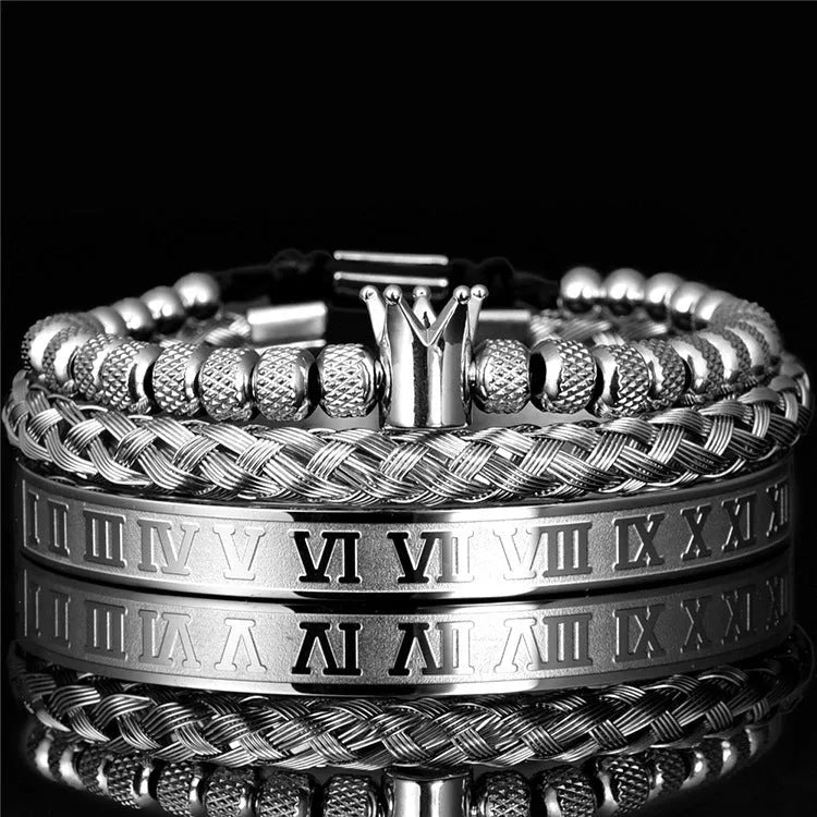 Adjustable crown charm bracelet in stainless steel with zircon detail, available in gold, silver, and black finishes.