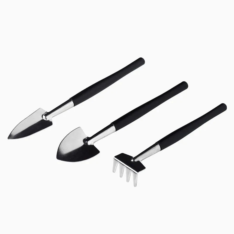 Succulent gardening tools set with mini shovel, tweezers, scissors, watering bottle, and cushion on a table.