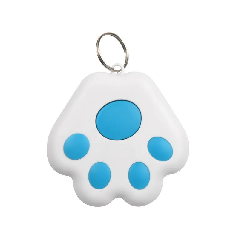 Small black dog paw shaped Bluetooth anti-lost device on a keyring next to a mobile phone.