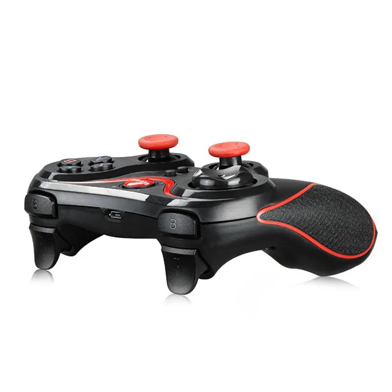 Black wireless Bluetooth gamepad for mobile phones on a table next to a charging cable.