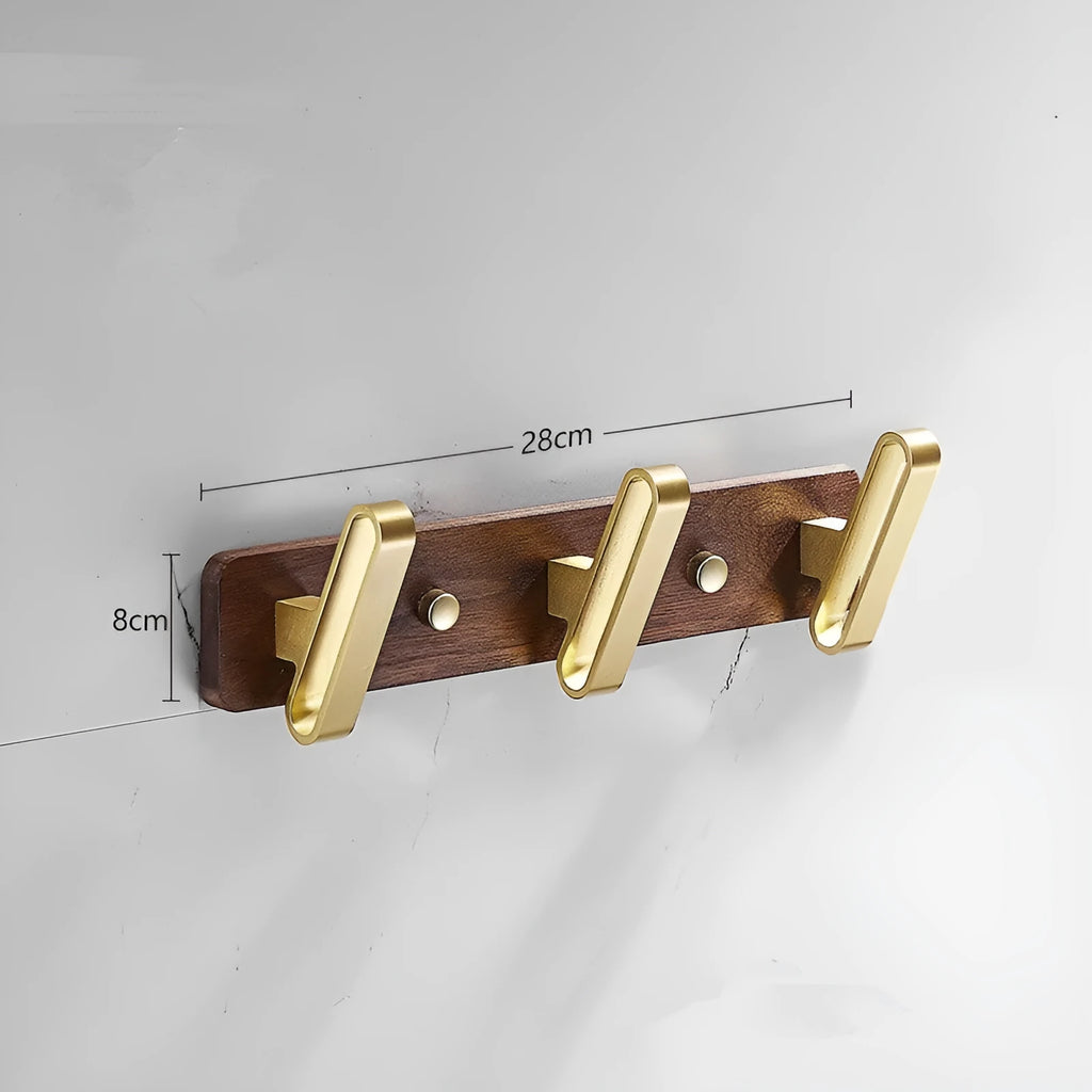 A row of black walnut bathroom clothes hooks with brushed brass metal details on a perforated mounting strip.