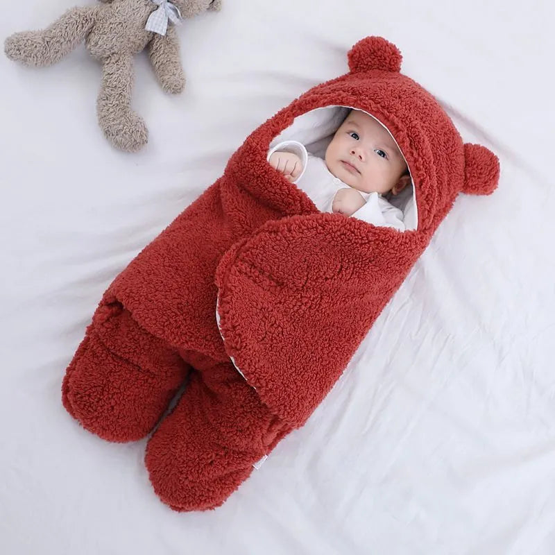 A baby quilted sleeping bag wrapper in a cotton blend fabric, shown in a light blue colour, laid flat.