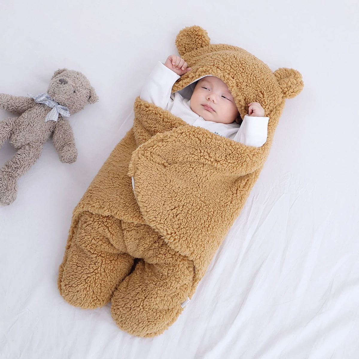 A baby quilted sleeping bag wrapper in a cotton blend fabric, shown in a light blue colour, laid flat.