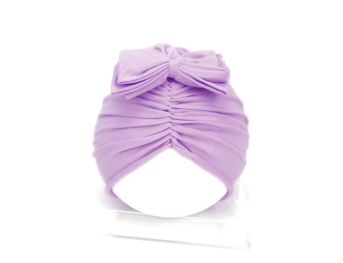 Soft acrylic knitted baby hat turban for infants and toddlers aged 0 to 28 months in a solid colour.