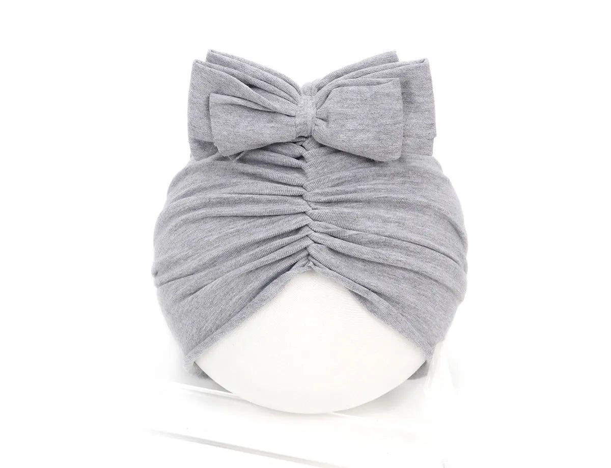 Soft acrylic knitted baby hat turban for infants and toddlers aged 0 to 28 months in a solid colour.
