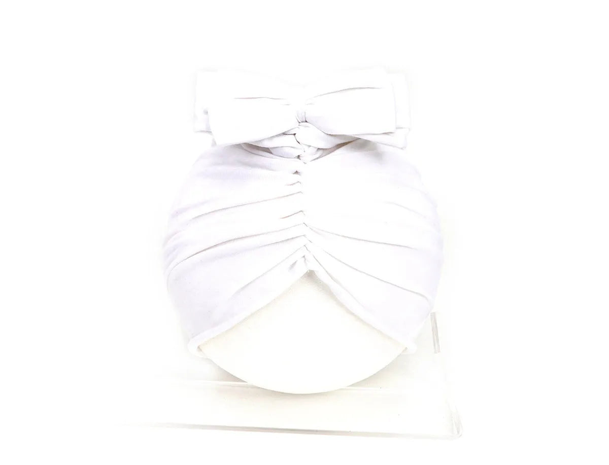 Soft acrylic knitted baby hat turban for infants and toddlers aged 0 to 28 months in a solid colour.