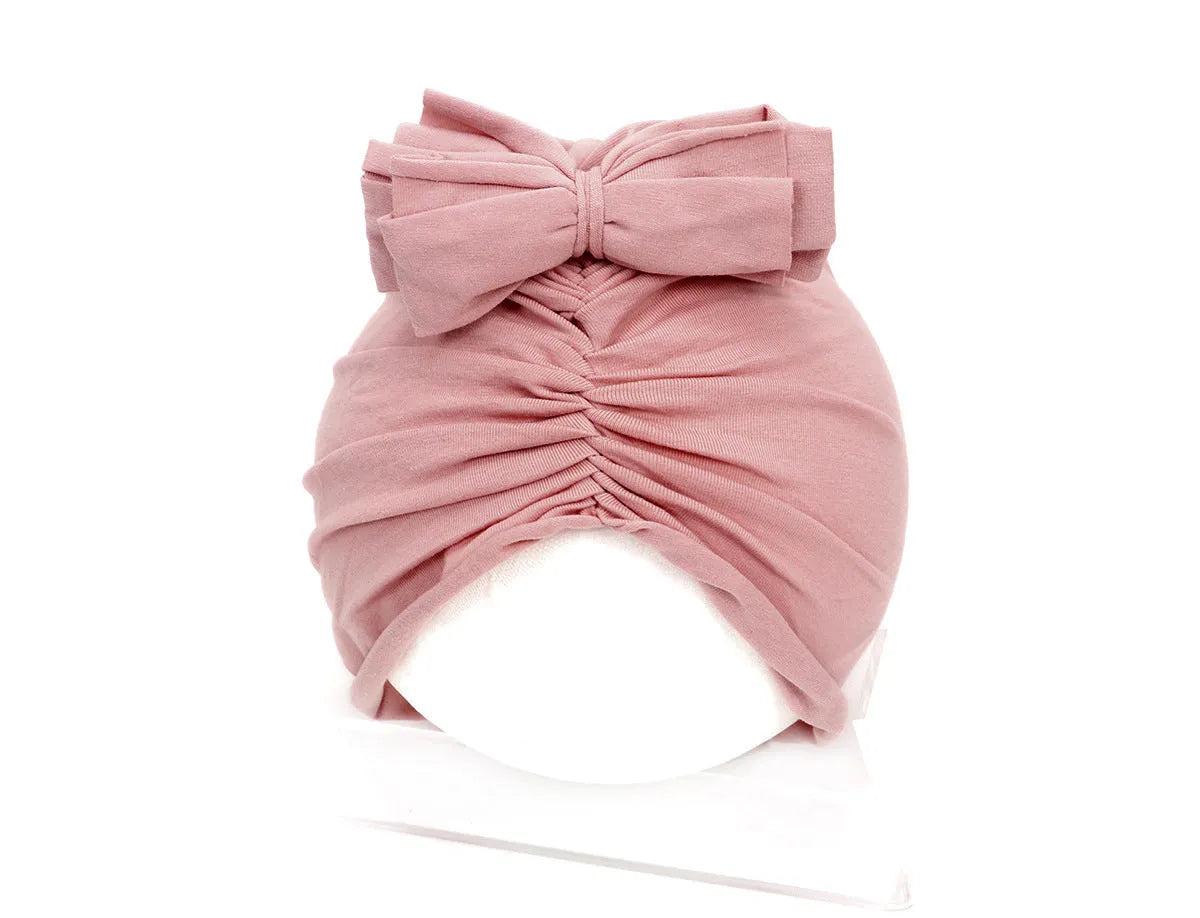 Soft acrylic knitted baby hat turban for infants and toddlers aged 0 to 28 months in a solid colour.