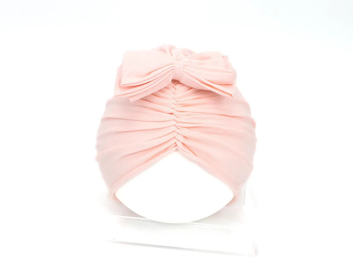Soft acrylic knitted baby hat turban for infants and toddlers aged 0 to 28 months in a solid colour.