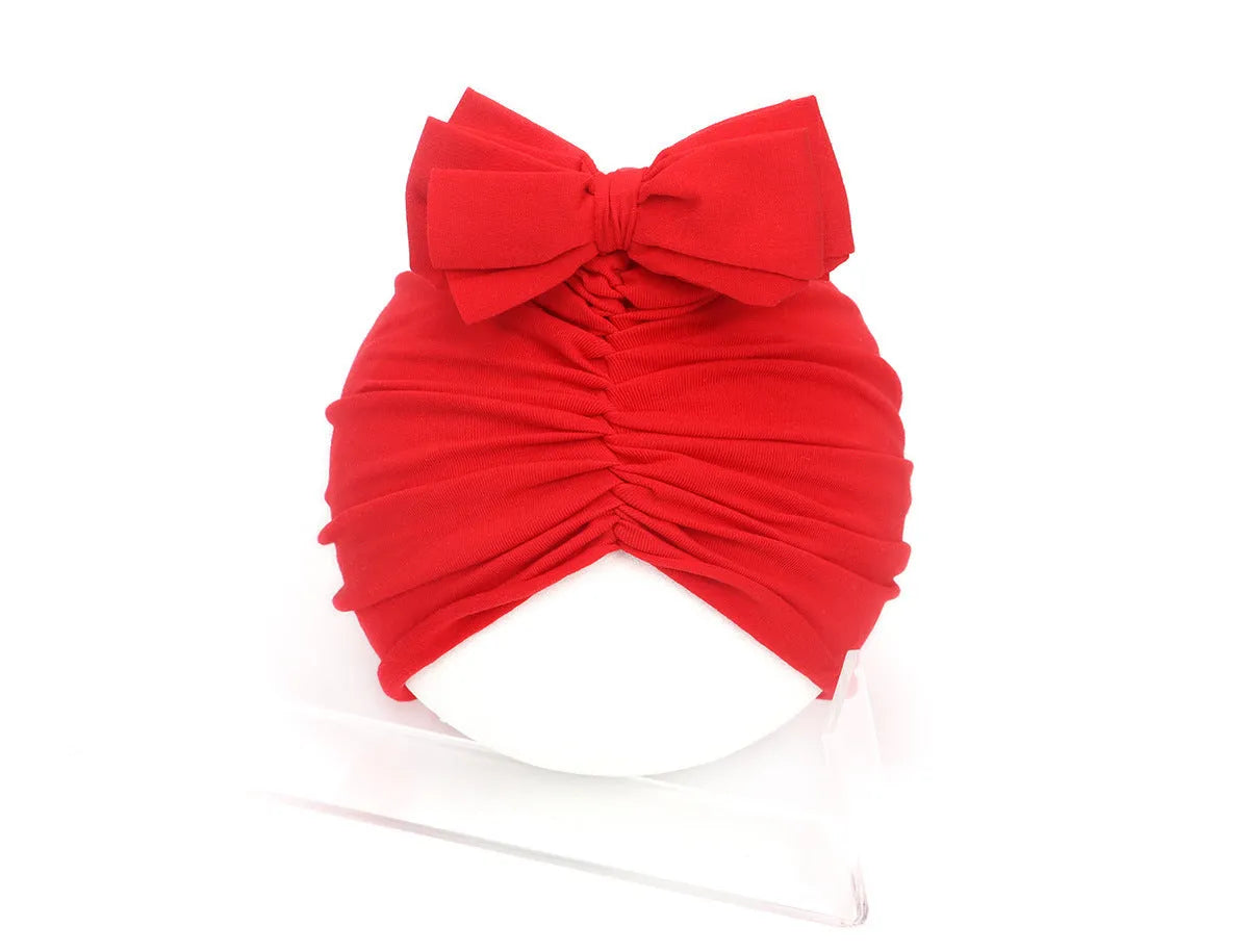 Soft acrylic knitted baby hat turban for infants and toddlers aged 0 to 28 months in a solid colour.