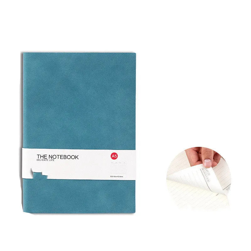Simple solid colour A5 notebook with thickened pages open on a desk, showing lined paper.