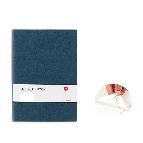 Simple solid colour A5 notebook with thickened pages open on a desk, showing lined paper.