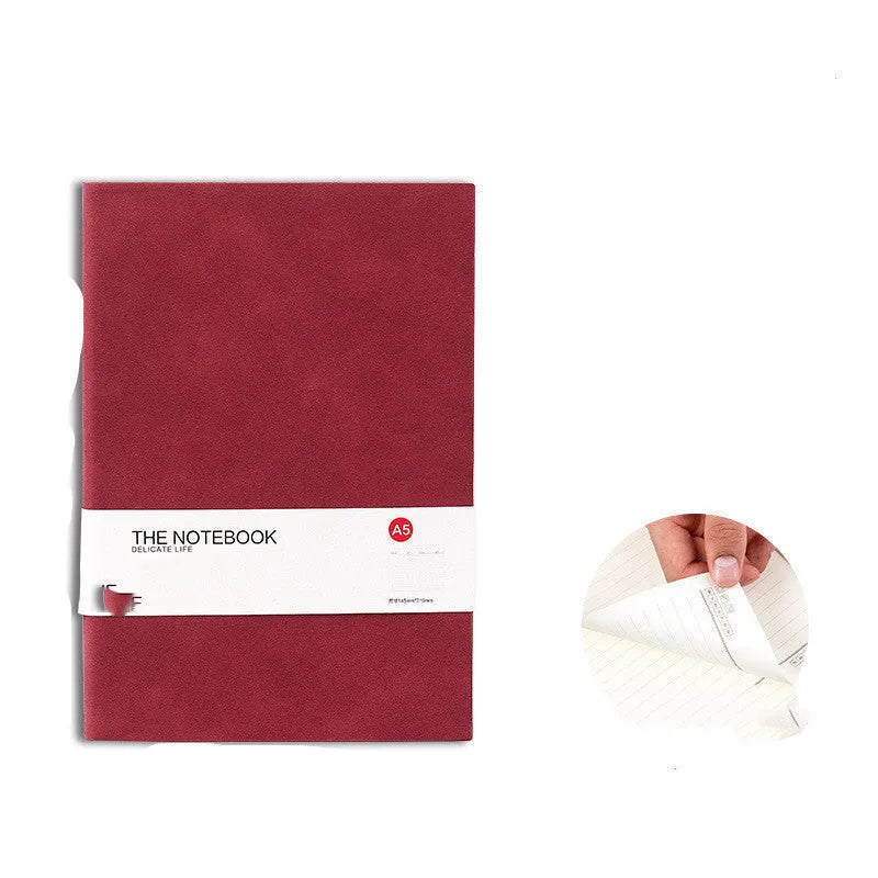 Simple solid colour A5 notebook with thickened pages open on a desk, showing lined paper.