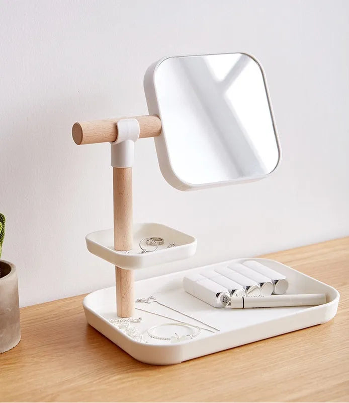 White desktop cosmetics storage box with mirror holding makeup brushes and lipsticks on a dressing table