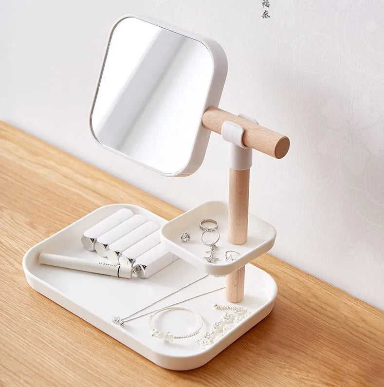 White desktop cosmetics storage box with mirror holding makeup brushes and lipsticks on a dressing table
