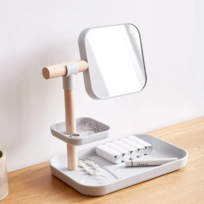 White desktop cosmetics storage box with mirror holding makeup brushes and lipsticks on a dressing table