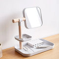 White desktop cosmetics storage box with mirror holding makeup brushes and lipsticks on a dressing table