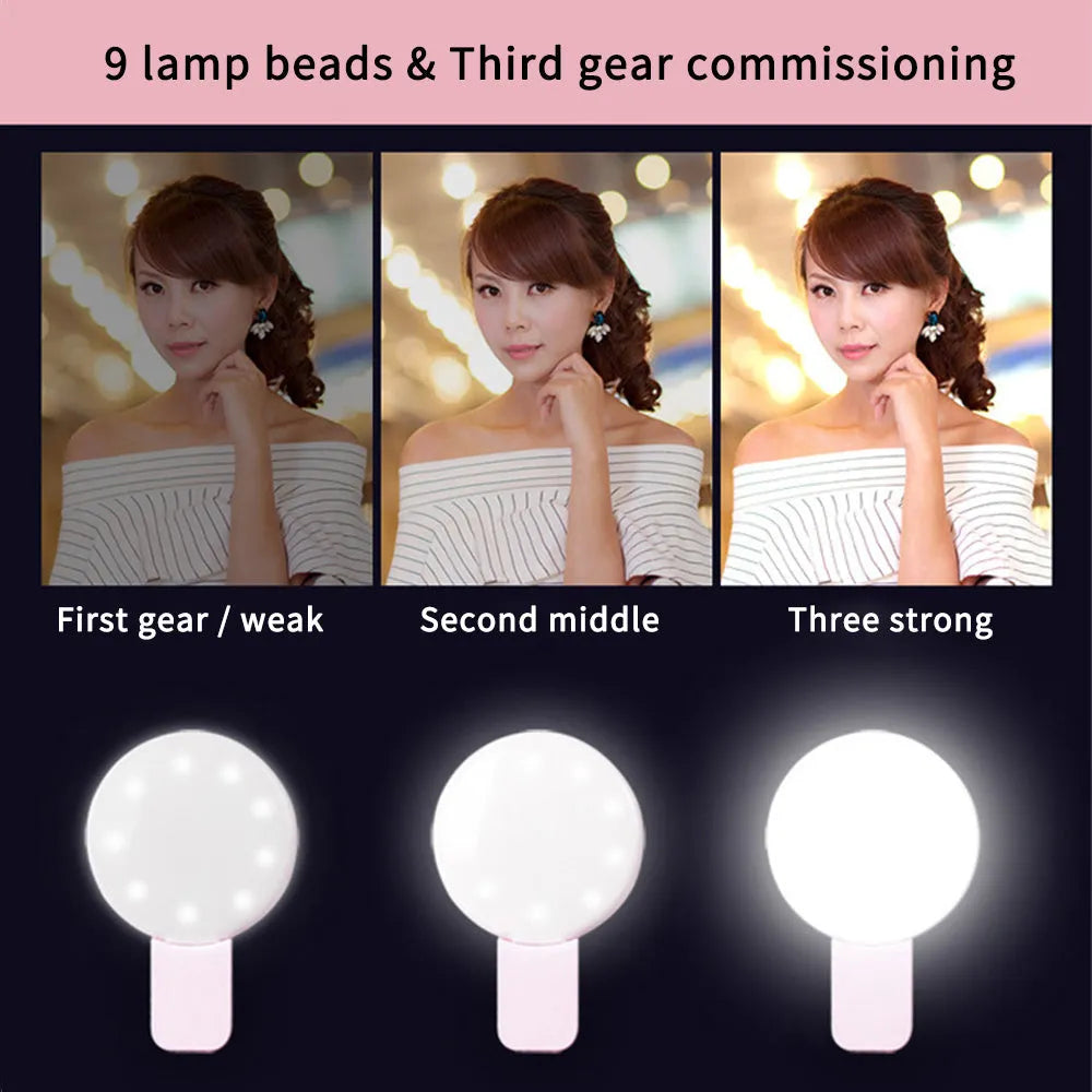 A white round clip-on LED mini fill light attached to a mobile phone.