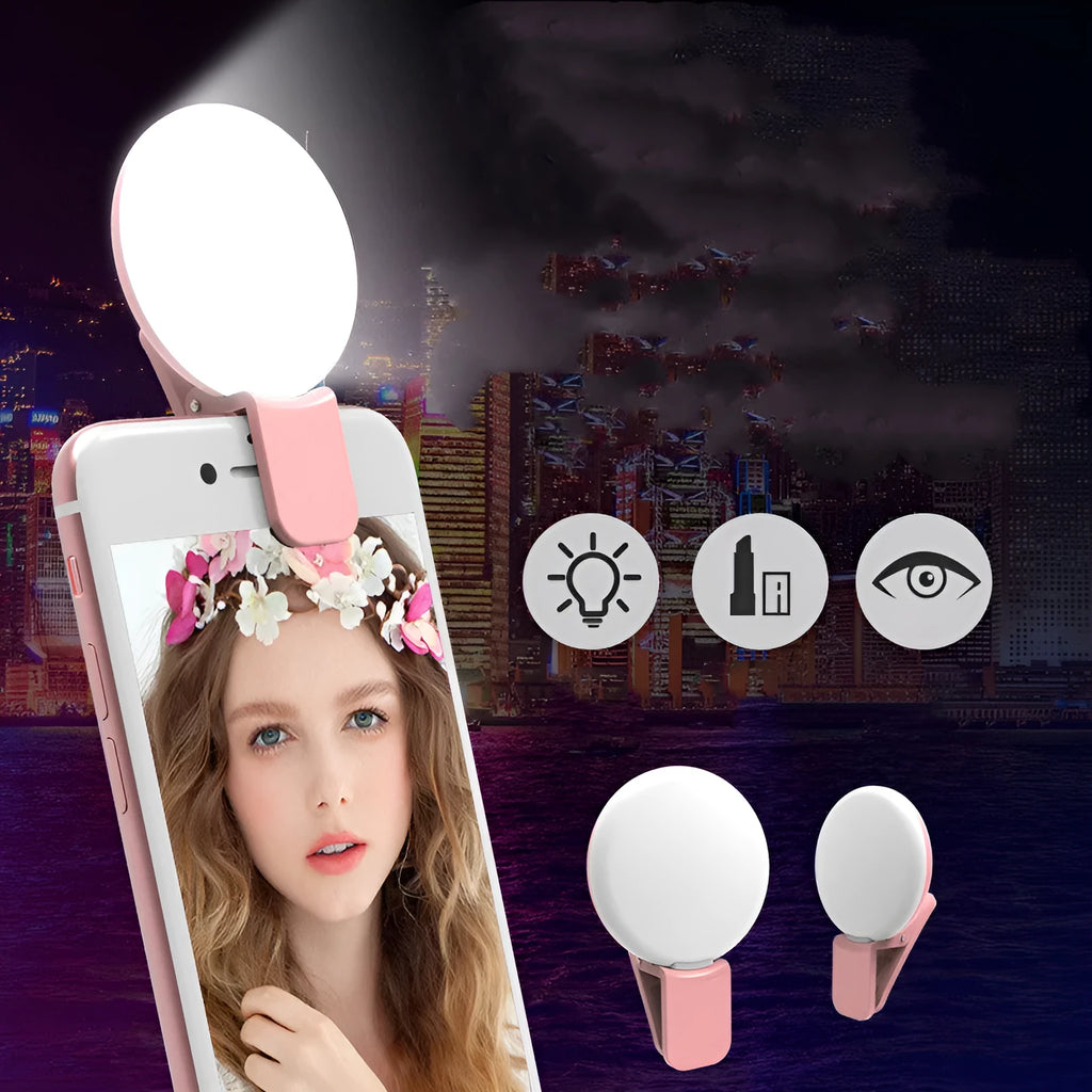 A white round clip-on LED mini fill light attached to a mobile phone.
