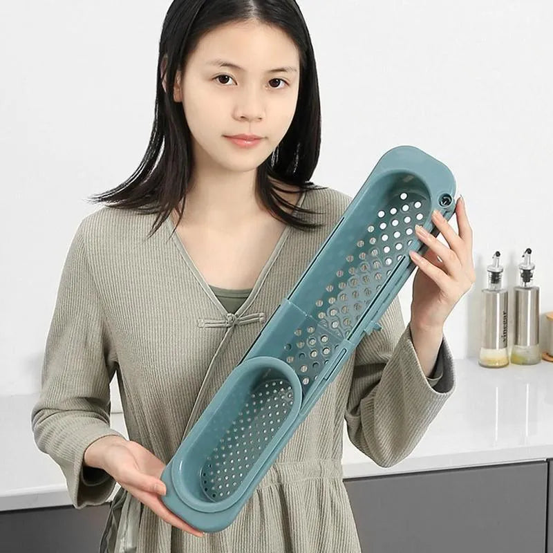 Adjustable telescopic kitchen sink rack organiser holding soap and sponge by drain