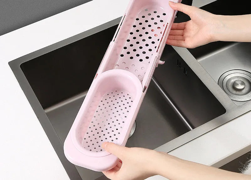 Adjustable telescopic kitchen sink rack organiser holding soap and sponge by drain