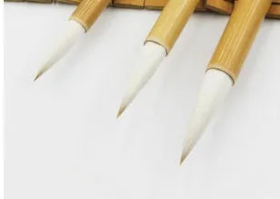 Three Chinese calligraphy brushes with bamboo handles and woolen hair bristles in different sizes