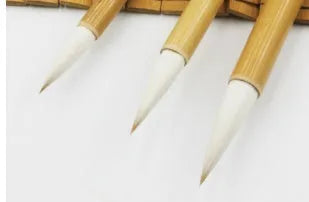 Three Chinese calligraphy brushes with bamboo handles and woolen hair bristles in different sizes