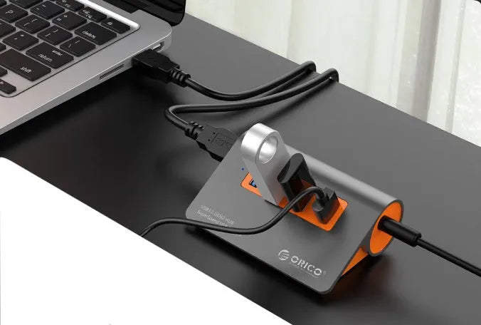 Dark grey and orange aluminium USB-C docking hub with four USB 3.1 ports and separate cable