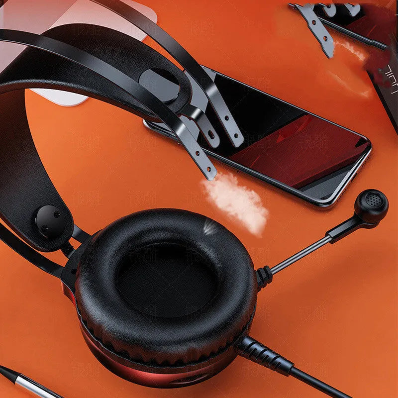 Black and white wired over-ear PC gaming headset with microphone on a desk.