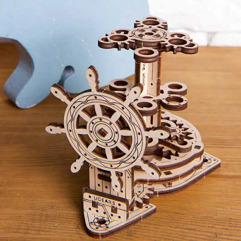 Ukrainian wooden rotating pen holder model with visible gears on a desk.