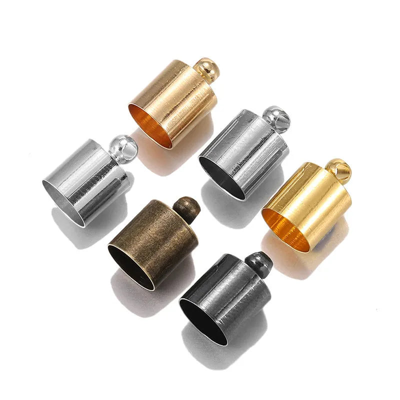 Assortment of small copper jewellery caps in different colours and sizes on a white background.