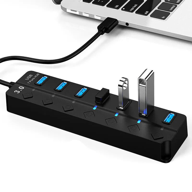 Black 7-port USB 3.0 hub with external power supply unit on a desk
