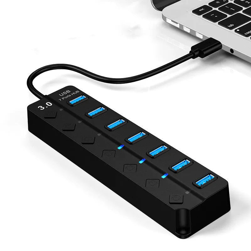 Black 7-port USB 3.0 hub with external power supply unit on a desk