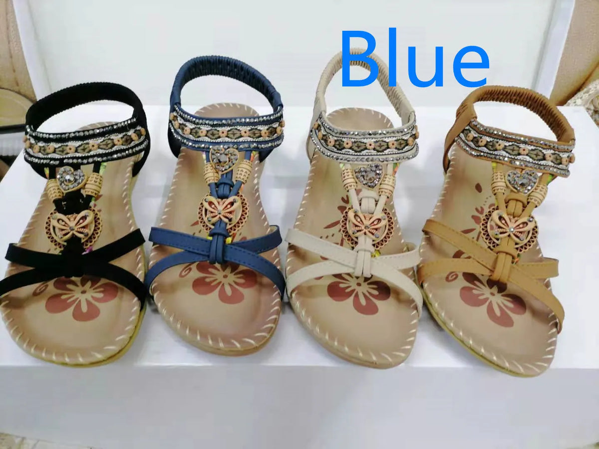 Large size flat sandals with flower and rhinestone detail, PU upper, round toe, and raw rubber sole in black, royal blue, apricot, or brown.