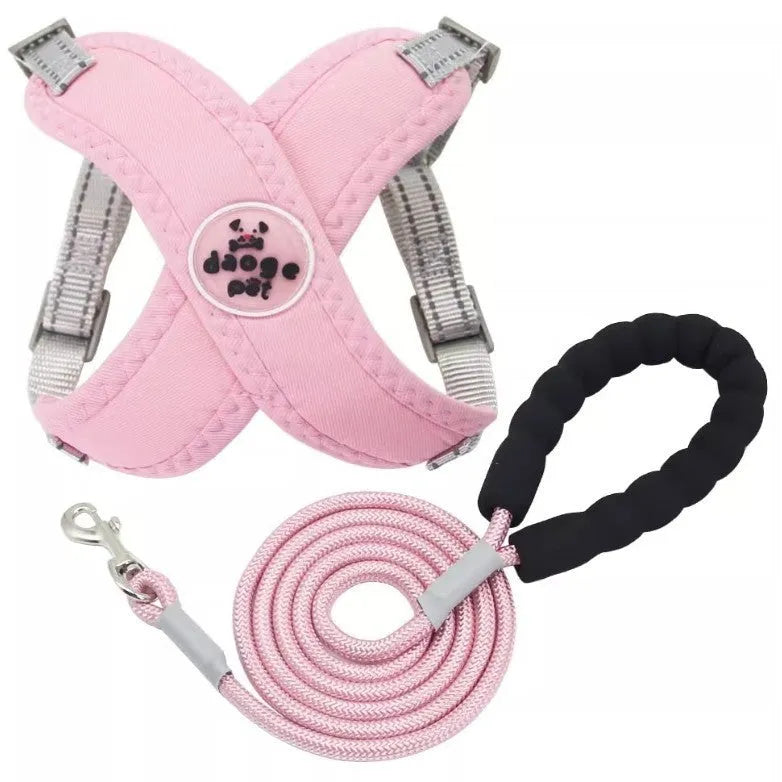 A pink polyester dog vest harness with an integrated hand holding rope laid flat.