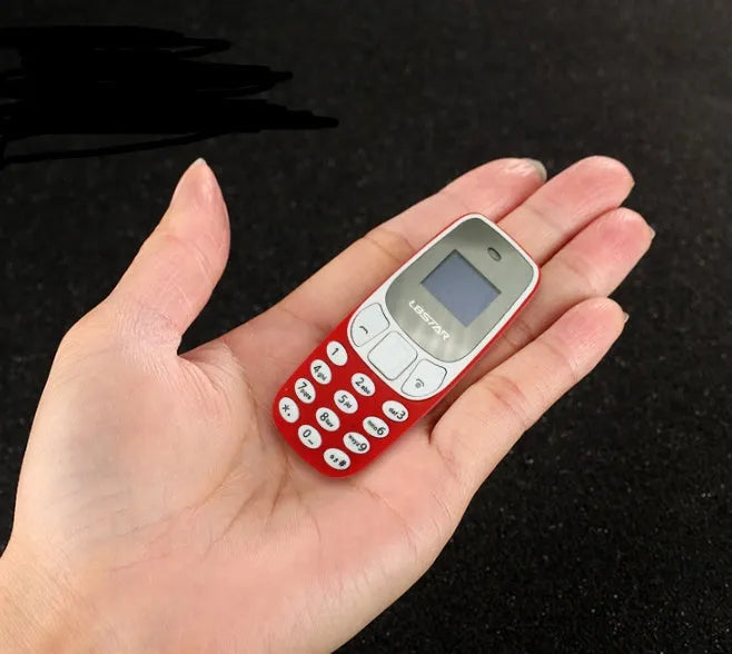 Miniature blue thumb phone with 0.66-inch OLED display, 68mm length, and keypad for dual SIM calling