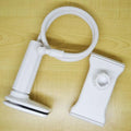 Black aluminium alloy and plastic bedside phone handset with long arm extended on a wooden table.