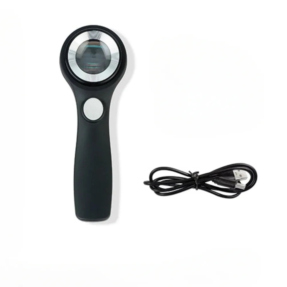 Black metal jeweller's loupe magnifying glass with adjustable stand on a wooden desk.