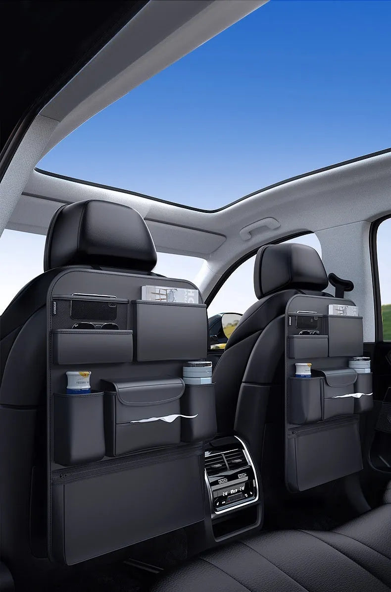 Black leather car seat back storage hanging bag with carrying handle shown attached to vehicle seat