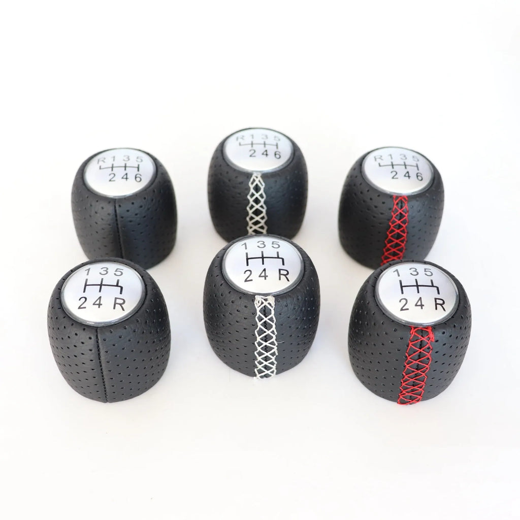 Sewn wrapped perforated leather gear handball for Toyota Alpha in matte and silver finishes.