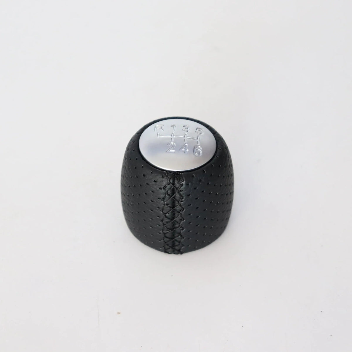 Sewn wrapped perforated leather gear handball for Toyota Alpha in matte and silver finishes.