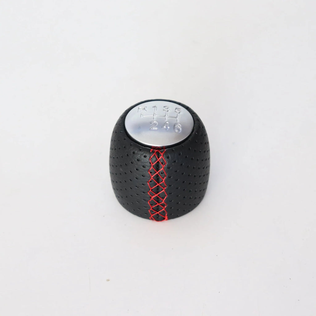 Sewn wrapped perforated leather gear handball for Toyota Alpha in matte and silver finishes.