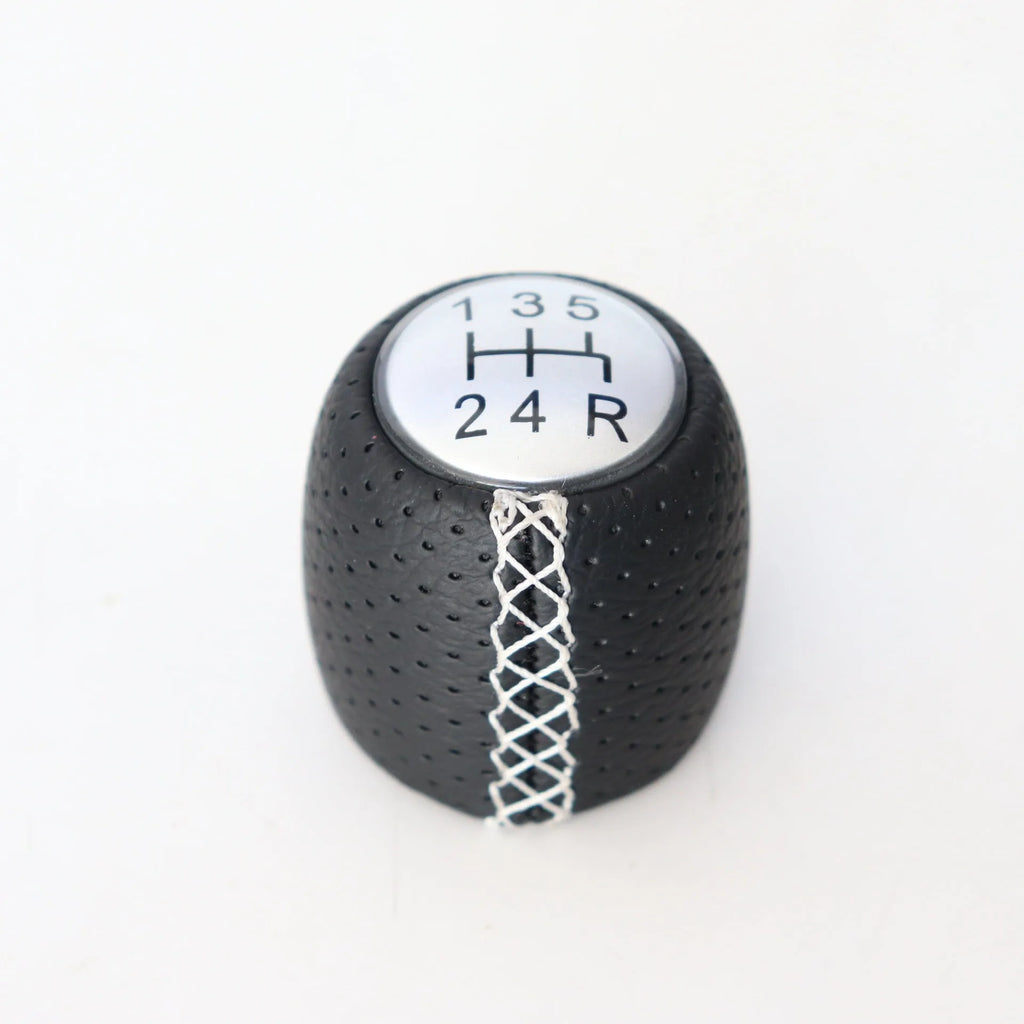 Sewn wrapped perforated leather gear handball for Toyota Alpha in matte and silver finishes.