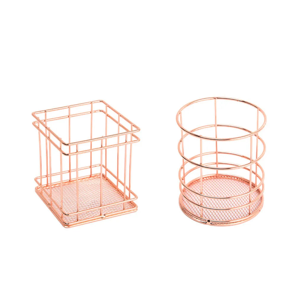 Rose gold iron wire square pen holder on desk holding pens and a ruler